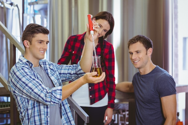 Man pouring beer into the beaker with a pipette