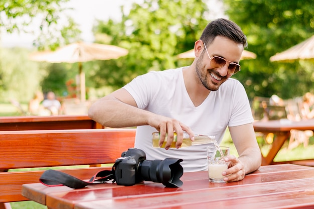 Man pouring drink in street cafe