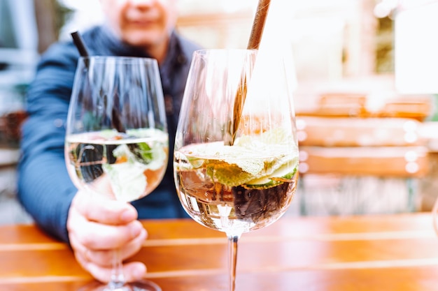 A man pouring wine into a glass with a straw.