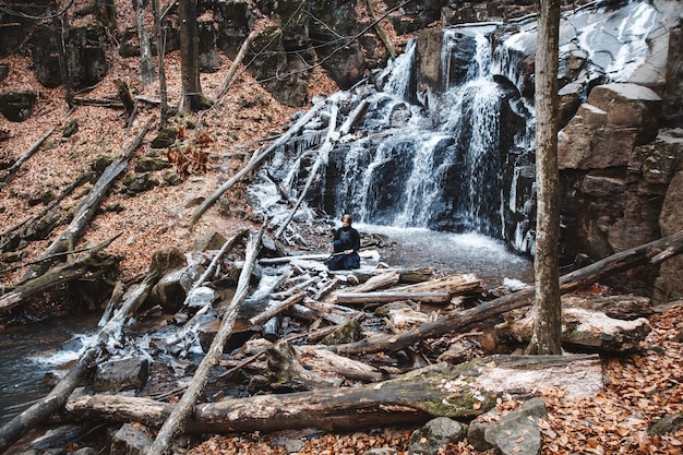 Man practicing kendo with bamboo sword on waterfall background