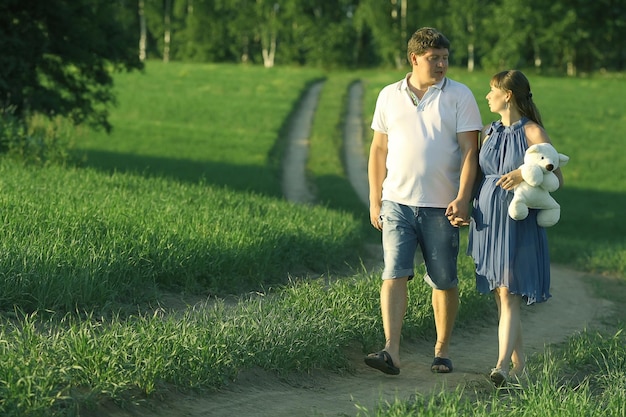 man and a pregnant woman in the field on the road happiness