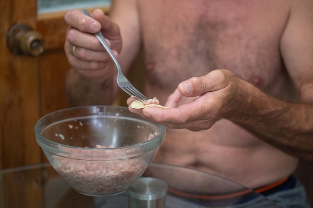 a man prepares dumplings with minced meat