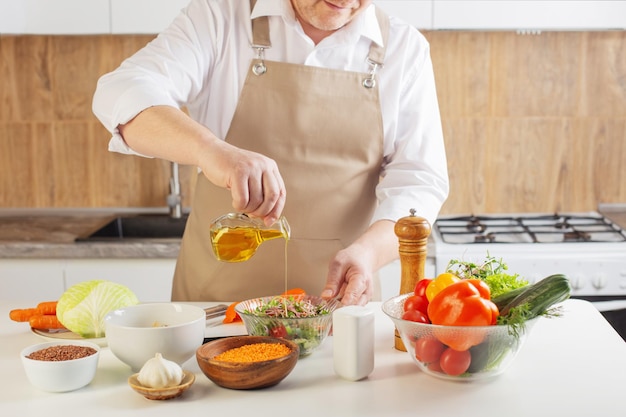 Man preparing healthy vegetarian food on table in kitchen