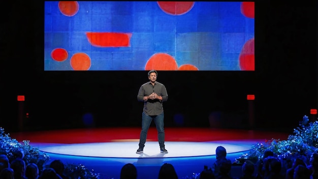 Man presenting on stage with colorful backdrop