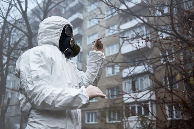 Man in protective clothing taking leave for analysis