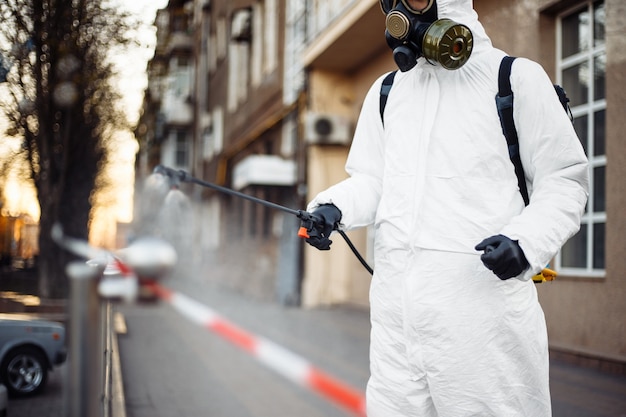 Man in protective equipment disinfecting the city