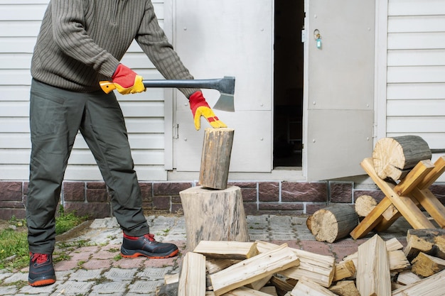 Man in protective gloves chopping wood