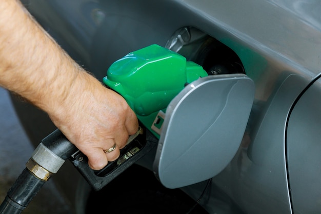 Man pumping gasoline fuel in car transportation at gas station