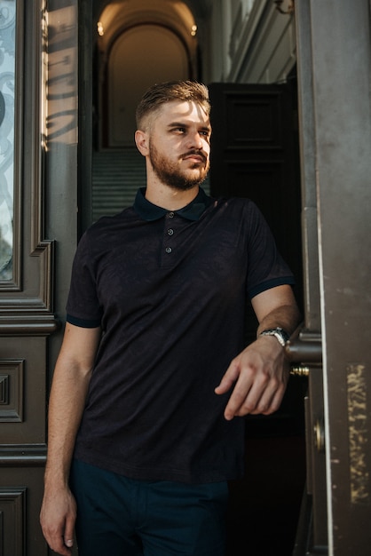 A man in a purple polo and posing for advertising men's clothing. Shooting for men's clothing store