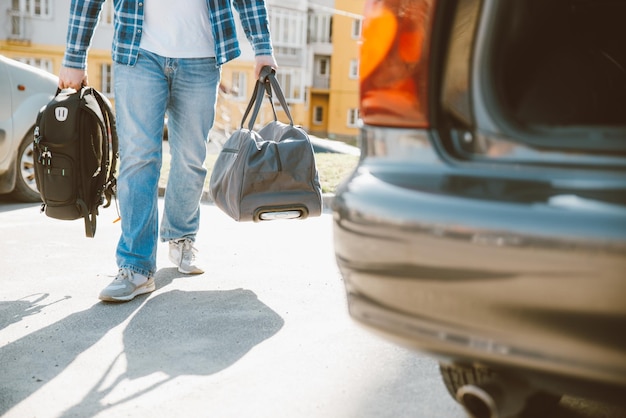 Man put bags to car trunk car travel concept