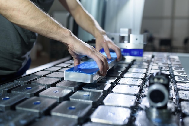 a man puts an aluminum piece on a cnc machine and prepares a processing machine
.