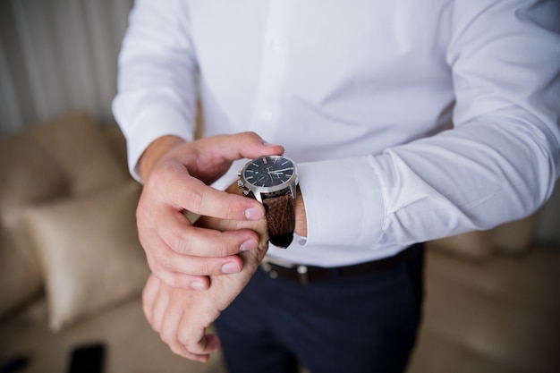 A man puts a classic watch on his hand