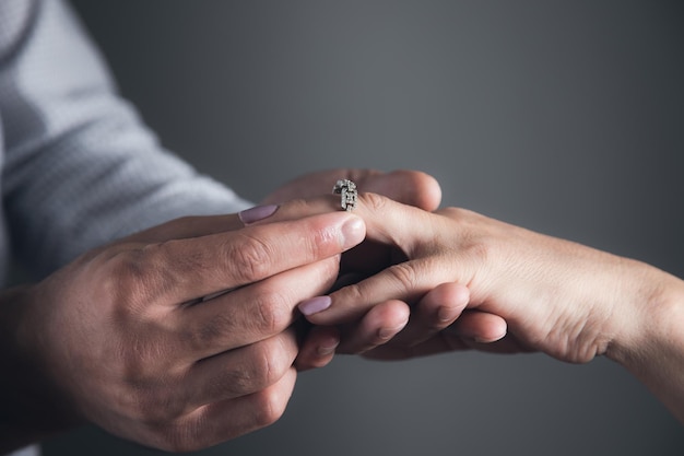 The man puts a ring on the woman finger