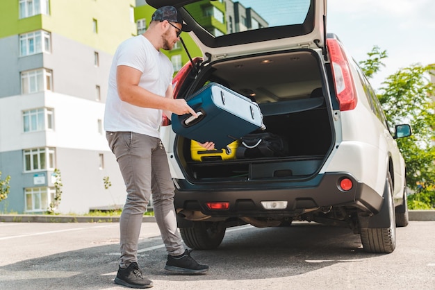 Man putting bags in car trunk ready for car travel