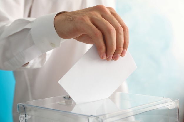 Man putting ballot into voting box