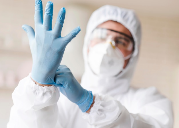 Man putting on blue gloves