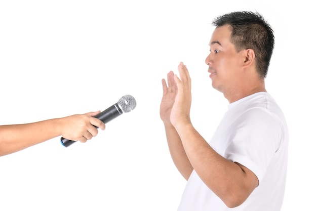 Man raises his hands to avoid speaking on microphone