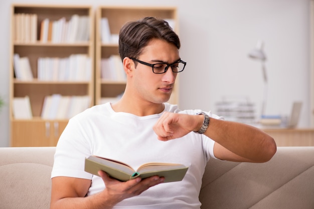 Man reading book sitting in couch sofa