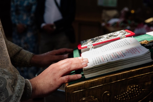 Man reading from the holy bible. Priest hands on bible