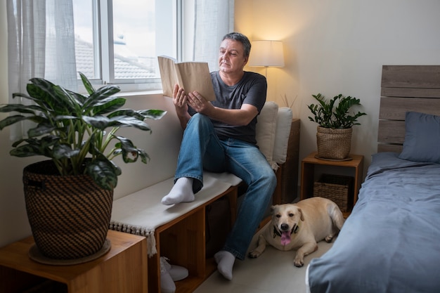 Man reading at home with his dog companion