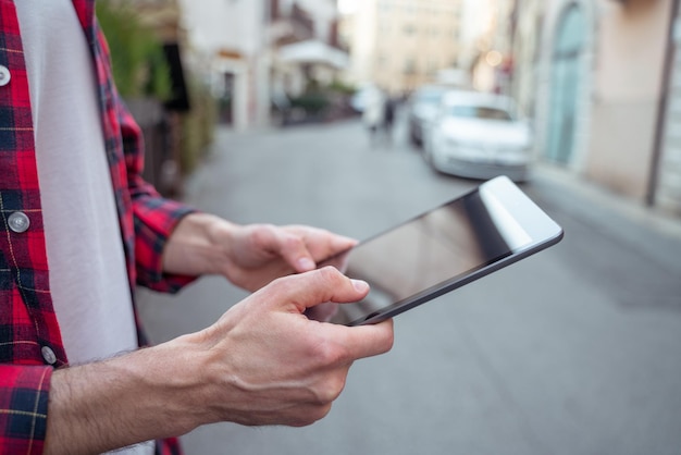 Man in red plaid shirt with a gadget in hands