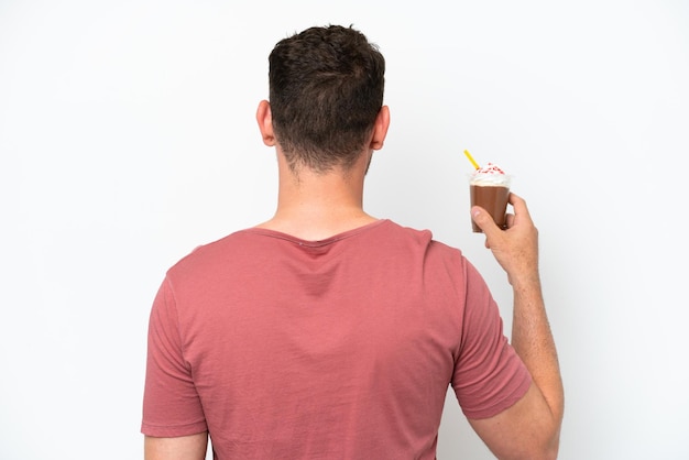 A man in a red t - shirt holds a cup of ice cream.