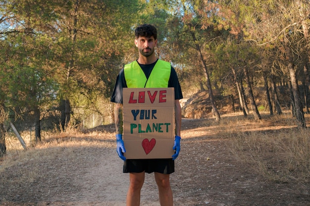 Man in a reflective vest with a sign protesting global pollution