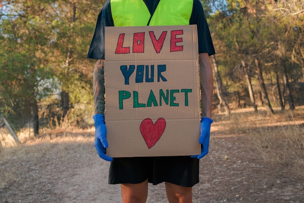 Man in a reflective vest with a sign protesting global pollution