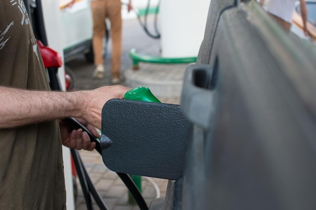 A man refuels a car at a gas station Sale of gasoline