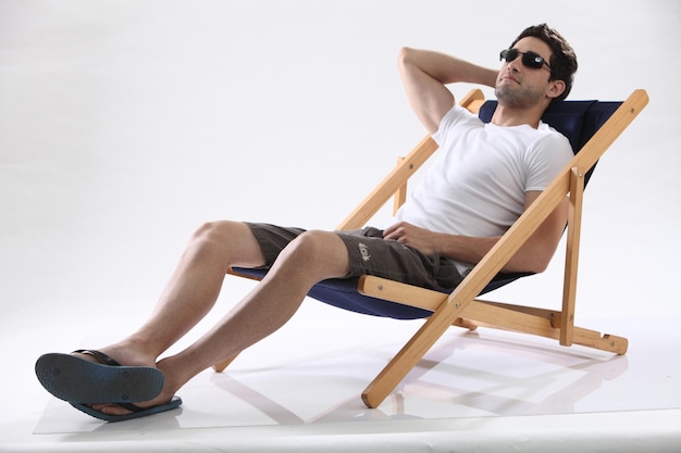 Man relax on the beach deck chair against white background