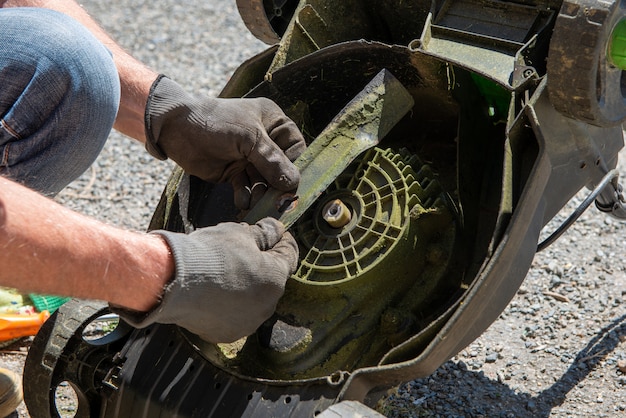 Man repairing an electric lawn mower