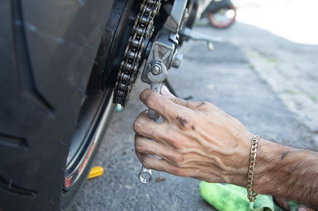 Man repairing motorcycle chain Sport Hobby