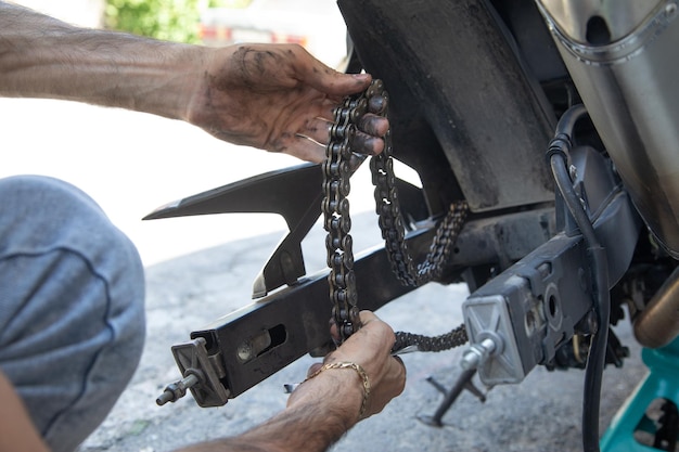 Man repairing motorcycle chain Sport Hobby