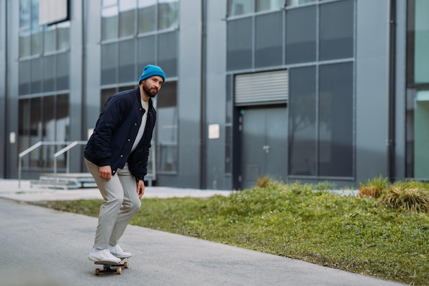 Man rides at skateboard Modern building in background High quality photo