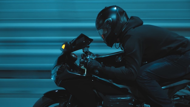 A man rides a sports motorcycle through the city at night