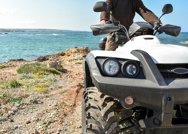 A man riding ATV in sand in protective helmet