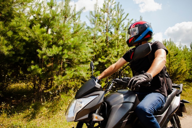 Man riding motorbike on dirt road with helmet