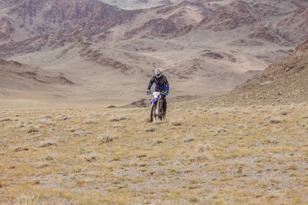 Man riding a motorbike in the steppes of Mongolia, on the hills of Mongolia