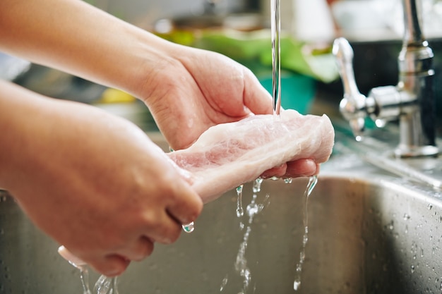 Man rinsing meat