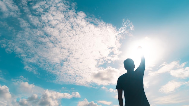 Man rise hand up to amazing blue sky feel never give up and freedom