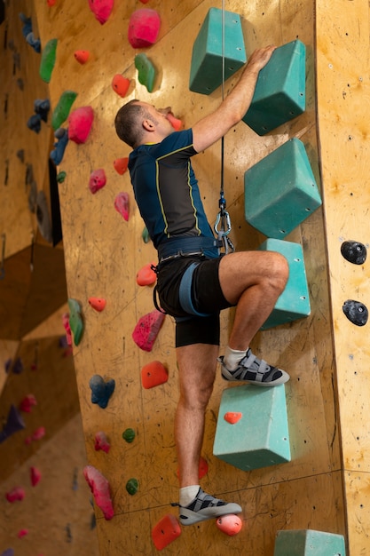 Man rock climbing indoors in the arena