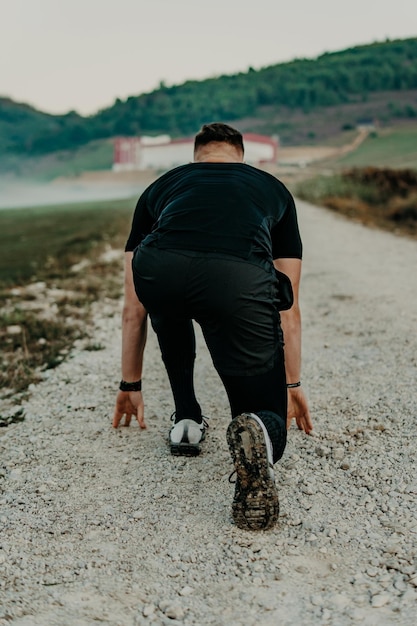 Man running / sprinting on road in mountains. Fit male fitness runner during outdoor workout. Young caucasian man.