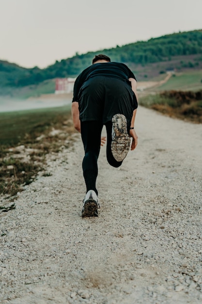 Man running / sprinting on road in mountains. Fit male fitness runner during outdoor workout. Young caucasian man.