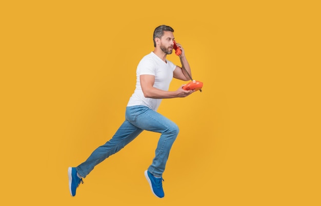 Man running with telephone in midair man call isolated on yellow background man has urgent call