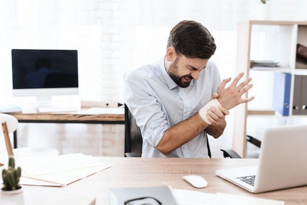 A man's arm hurts. His face is grimacing with pain.