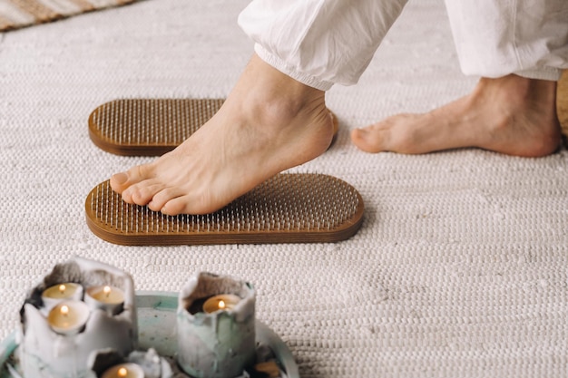 The man's feet are next to boards with nails Yoga classes