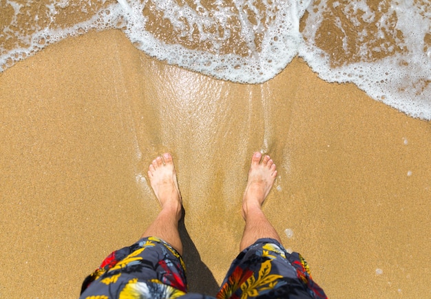 Man's feet on the beach