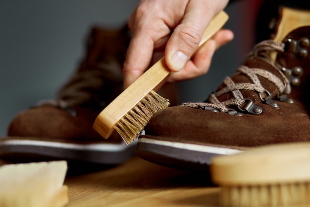 Man's hand cleans suede shoes with brush