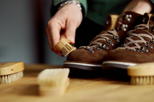 Man's hand cleans suede shoes with brush