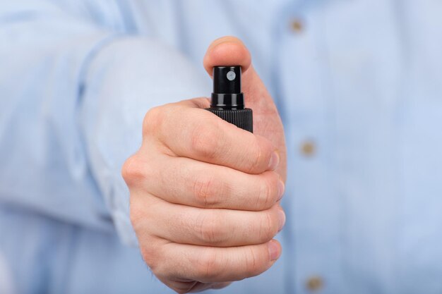 Man's hand holds protective antibacterial spray Front view Close up